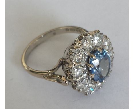 An 18ct. Gold Diamond and Tanzanite Cluster Ring. Size M. Tanzanite 1.5 carat, Diamond 1 carat approx.