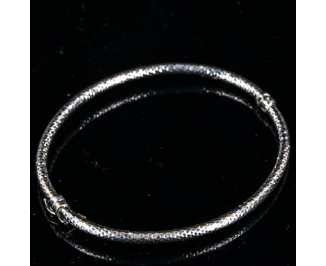 A modern 9ct white gold hinged bangle, faceted oval form, internal dimensions 6cm x 5cm, 4.8gNo damage or repairs, only light