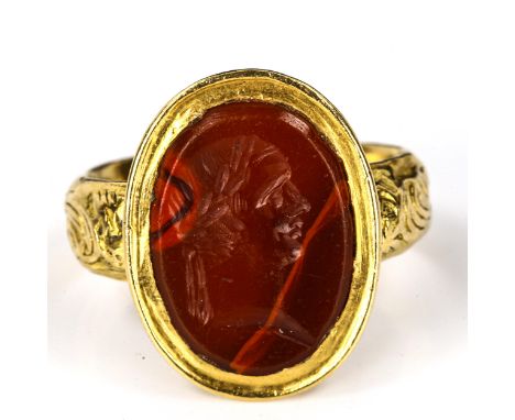 An Antique hardstone seal ring, heavy unmarked high carat gold settings, with intaglio carved male profile with laurel wreath