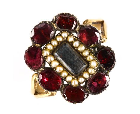 A Victorian split pearl and flat-top garnet memorial ring, unmarked yellow metal settings with central vacant panel under con