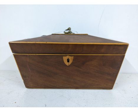 An early 20th century mahogany tea caddy of sarcophagus form with a hinged lid, revealing two interior lidded compartments an