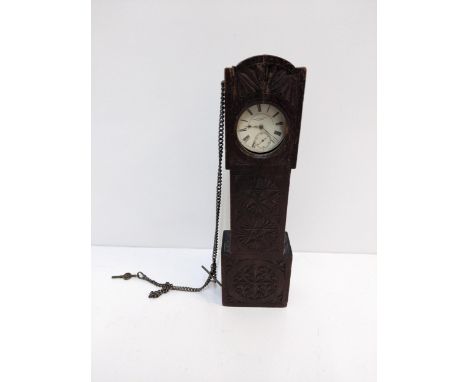 A wooden carved pocket watch holder fashioned as a grandfather clock containing a silver Fattorini &amp; Sons pocket watch Lo