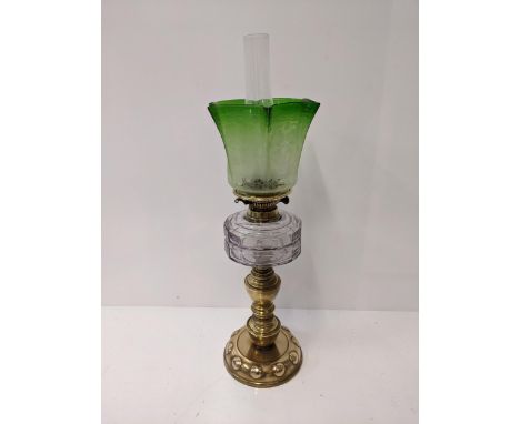 A Victorian oil lamp on a rounded brass plinth with a green glass shade with floral design, 67cm high Location: If there is n