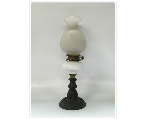 AN EARLY PARAFFIN LAMP ON A WRIGHT AND BUTLER SLIP WICK BURNER AND CHINA FONT, CAST IRON BASE (In-house packing unavailable f