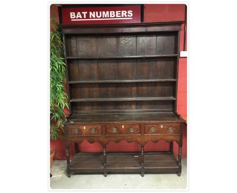 A GEORGE III OAK DRESSER, THE PLATE RACK WITH MOULDED CORNICE AND THREE FIXED SHELVES, THE LOWER PART CONTAINING THREE FRIEZE