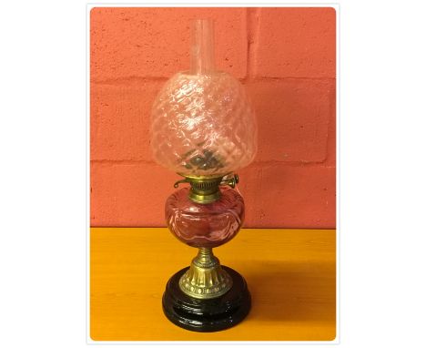 A BRASS OIL LAMP WITH CRANBERRY FONT AND SHADE 