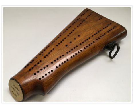 A RIFLE BUTT CRIBBAGE BOARD WITH 'SUDAN MARINE CLUB' PLAQUE TO END 