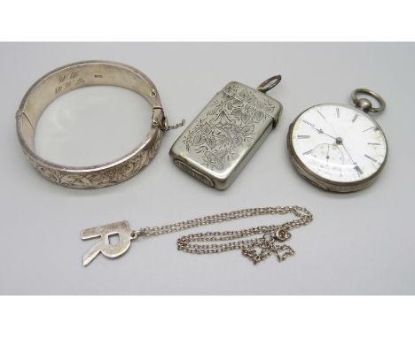 A silver bangle, 26g, a white metal pocket watch, a plated vesta case, and a silver 'R' pendant on a white metal chain