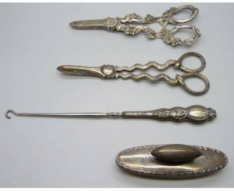Two pairs of plated grape scissors, one with snake handles, the other with bunches of grapes, a silver nail buffer and a butt