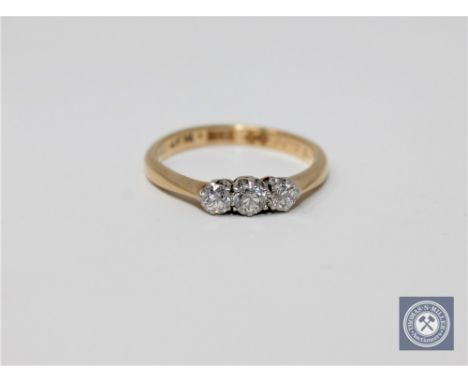 An 18ct gold three stone ring, approximately 0.33ct, size K.