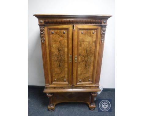 An antique continental mahogany double door cabinet with walnut panel doors