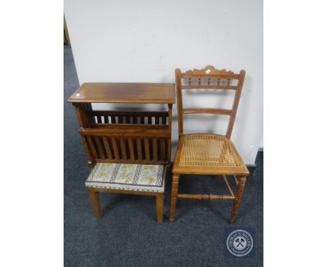 An Edwardian oak bergere seated bedroom chair together with a tapestry upholstered stool and a magazine rack