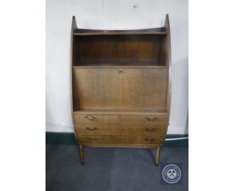 A mid 20th century Danish teak writing bureau fitted shelf above and three drawers beneath