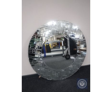 A large circular all glass framed mirror 