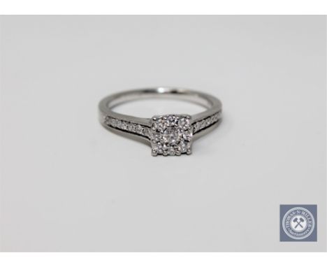 A platinum and diamond cluster ring set with diamond shoulders, size K 1/2.