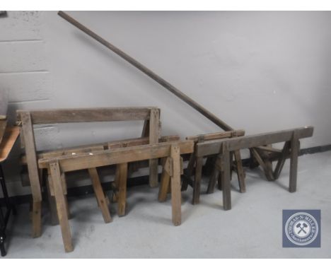 Seven vintage wooden trestle stands together with a wooden post