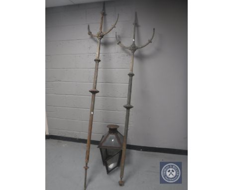 Two antique cast iron three way gas light posts and a glass and metal lantern 