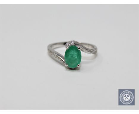 A 14ct white gold emerald and diamond ring featuring an oval cut emerald 1.18ct with 64 round brilliant cut diamonds 0.24ct. 