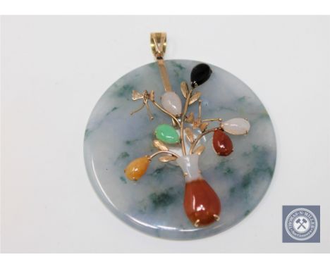 A large jade disc pendant set with various coloured jade mounted in gold