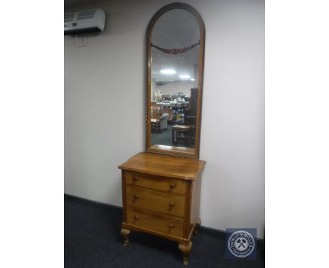 A continental walnut three drawer hall chest with dome topped mirror