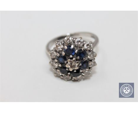 An 18ct white gold diamond and sapphire cluster ring, approximately 0.9ct.