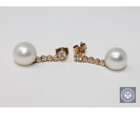 A pair of 14ct yellow gold white pearl and diamond earrings, featuring two white pearls, two brilliant cut diamonds 0.15ct an