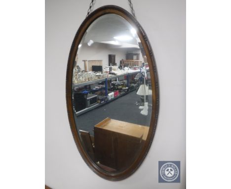 An Edwardian mahogany oval framed bevelled mirror 