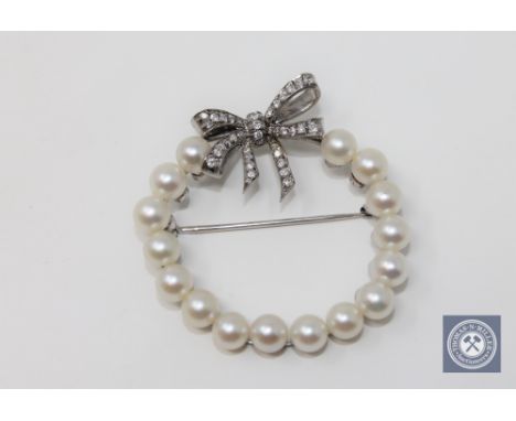 A 14ct white gold pearl and diamond set brooch