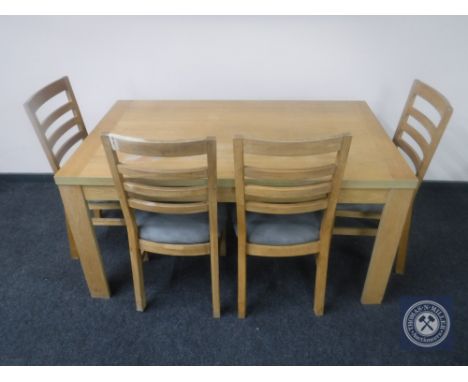 A contemporary oak effect dining table together with a set of four ladder back chairs