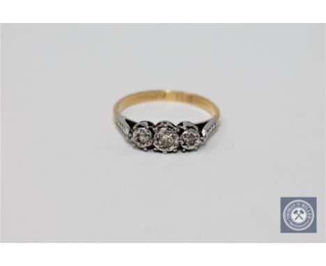 An 18ct gold and platinum set three stone diamond ring, approximately 0.25ct, size K 1/2.
