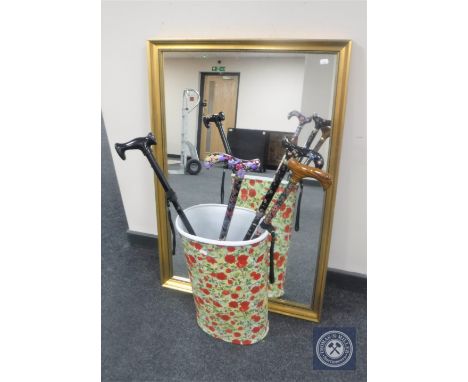 A gilt framed mirror together with a stick pot with rose decoration and four folding walking sticks 