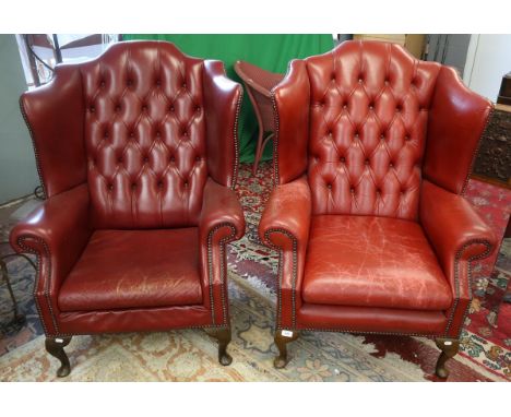 Pair of red leather button-back wing armchairs 