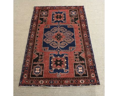 A 20th Century Caucasian Rug A 20th Century Caucasian Rug, possibly Kazak, bearing scroll and star motifs on a navy and dark 