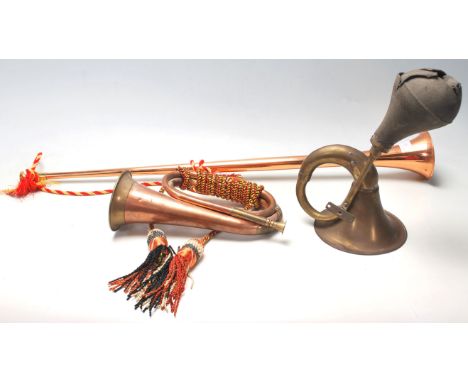A collection of early 20th Century brass horns to include a pair of hunting horns with tassels and a car horn.&nbsp;&nbsp;