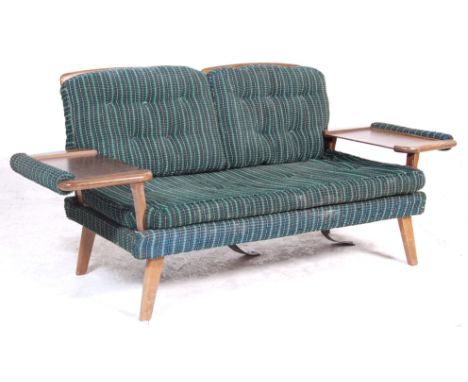 A vintage retro Danish Influenced 1970's sofa bed / settee having a wooden frame with rail backrest with folding armrests to 