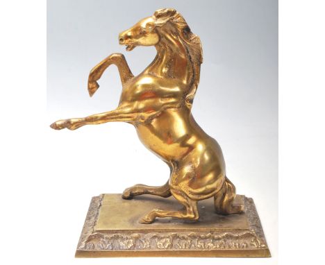 A vintage 20th century brass horse mantle ornament sitting on the back legs with front legs raised. Monted on a plinth base w