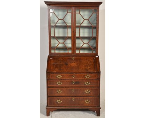 A George III 18th century mahogany and marquetry inlaid cross-banded bureau bookcase. Raised on bracket feet with a bank of d