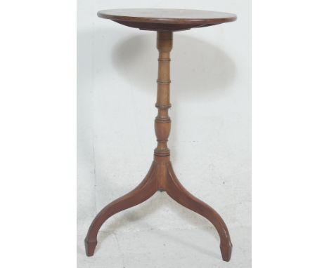 A 19th&nbsp;century George III mahogany tripod wine table being raised on splayed legs with turned columns having a circular 