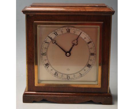 An mid century 1960s Oak mantle clock having a pediment stepped top over a large brass and brushed metal clock face having ro