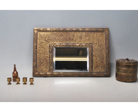 A 20th Century Arts and Crafts style mirror having a brass hammered frame with central bevelled mirror, a round early 20th Ce