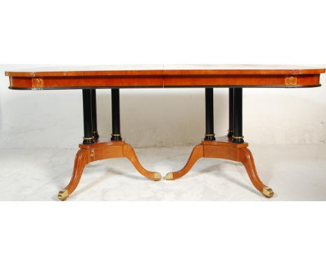 A large impressive regency revival dining table consisting of a maple, satinwood, ebony &amp; boxwood top set upon a pair of 