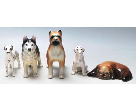 A collection of 20th Century ceramic figurines of dogs in various shapes and sizes to include a Beswick Dalmation, a Boxer, a