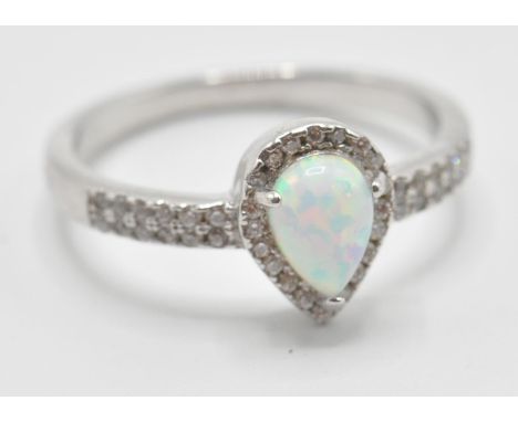 A stamped 925 silver ring having a central opal stone in a shape of teardrop and CZ accent stones. Size P, weight: 2.90g