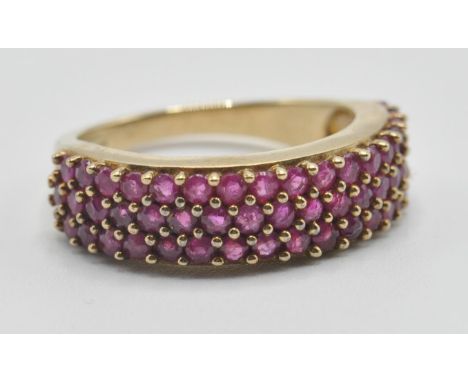 A hallmarked 9ct gold and ruby band ring being set with three rows of pink rubies. Hallmarked Birmingham 2008. Weight 4g. Siz
