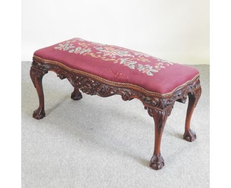 A carved serpentine footstool, with a tapestry seat, 100cm