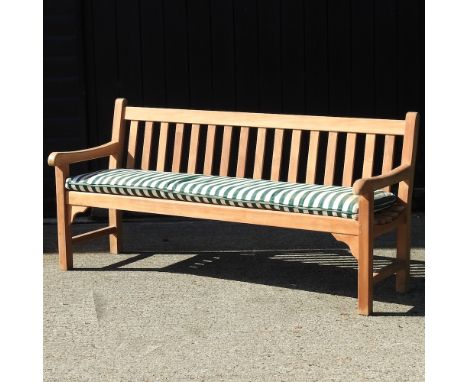 A teak slatted garden bench, with a loose cushion, 182cm