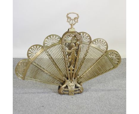 An ornate brass adjustable fan fire screen, of peacock design, 85cm high