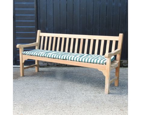 A teak slatted garden bench, with a loose cushion, 182cm