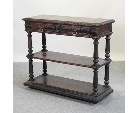 A Victorian carved oak three tier buffet, with a hinged marble inset top, 114cm