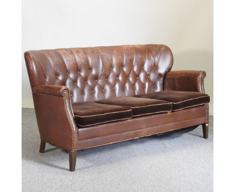 A 1920's brown leather upholstered sofa, with velvet cushions, 160cm